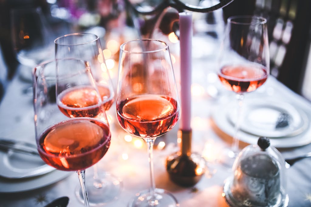 A chic table setting with rose wine glasses, perfect for a sophisticated evening gathering.